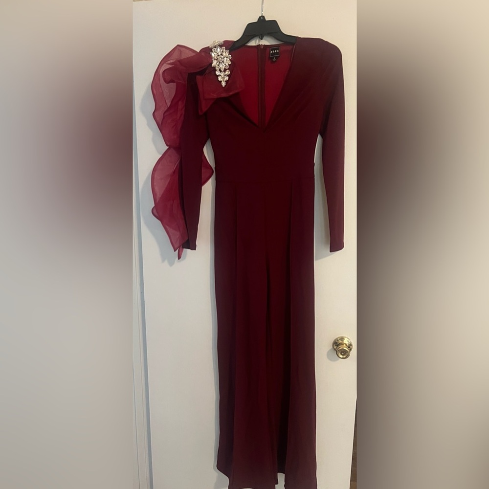 Wine colored jumpsuit with sleeve ruffle!
She is 🔥🔥🔥